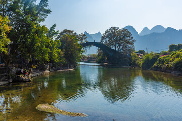 Fototapeta premium YANGSHUO, CHINA, 6 DECEMBER 2019: Fuli bridge on the Yulong River in the countryside of Yangshuo
