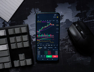 phone with stocks on screen on top of desk