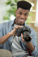 man at home reviewing photographs on his dslr camera