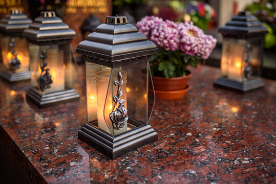 candles and white flowers on the tomb on All Saints' Day
