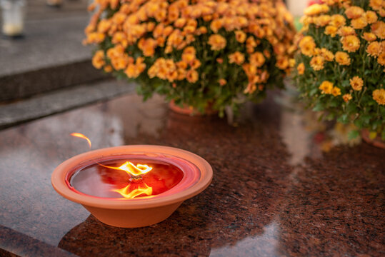 candles and white flowers on the tomb on All Saints' Day
