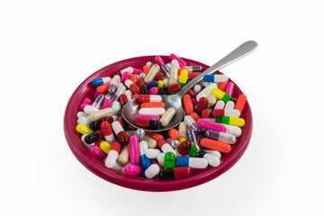 Bowl of pills and capsules with white background.