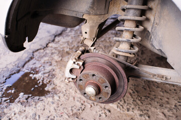 Hub, brake disc, pad, shock absorber of the rear wheel of a car being repaired at a service station, close-up