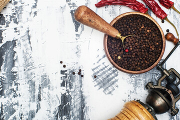 Pepper mill with chili peppers and chili on a light background. Flat lay top view.