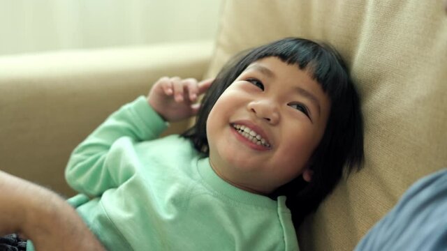 Positive little boy playing on sofa in living room  with happy. Son have fun enjoy family time at home at weekend.