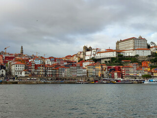 Naklejka premium View over old town skyline and port, harbor at sunset on the Douro river at Porto, Portugal 