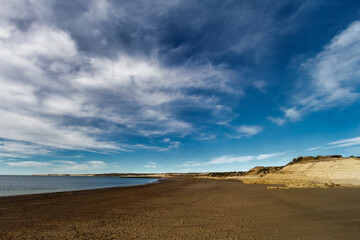 Fototapeta na wymiar Desolate beach with small cliffs at El Pozo beach, south of Puerto Madryn, Argentina