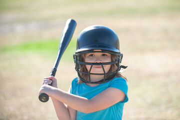 Fototapeta na wymiar Little child baseball player focused ready to bat. Kid holding a baseball bat.
