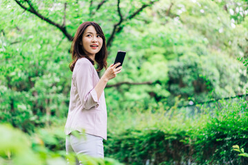 外でスマホを使うビジネスウーマン