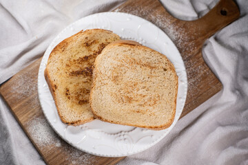 homemade bread on toast. two slices on a wooden base and white fabric