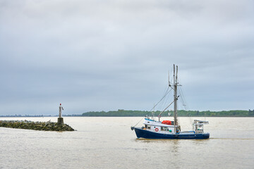 Fraser River Fishboat Returning. A fishboat returning from the Georgia Strait and Salish Sea to Steveston harbour on a grey day.


