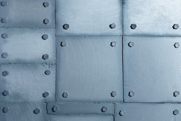 Fototapeta premium Background of silvery wall made of polyethylene foam sheets imitating metal with rivets.
