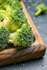 Board with healthy broccoli cabbage on color background, closeup