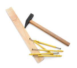 Wooden plank, hammer, screws and dowels on white background