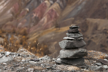 A pyramid of stone on top of a mountain on the background of mountains for meditation. Harmony.