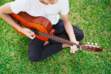 Young guy playing guitar in park