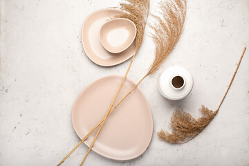 Dry common reeds and dishes on white background