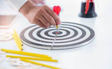 business man push dart to dartboard,concept business targeting and and marketing goal