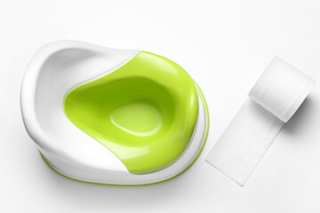 Baby potty and roll of toilet paper on white background