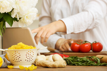 Colander with raw pasta and ginger on table in kitchen, closeup