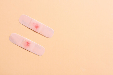 Medical plasters with drop of blood on color background