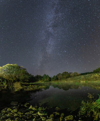 milky way over a river in a Russian village
