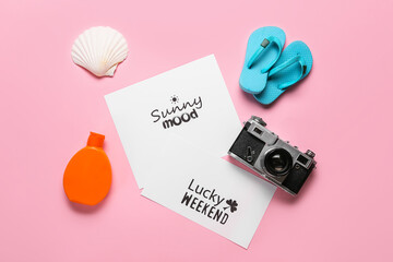 Paper sheets with motivations, photo camera, flip-flops and sunscreen cream on color background....