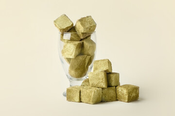 Glass with tasty hojicha marshmallows on light background