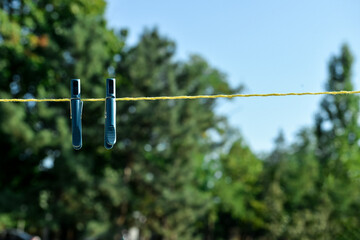 Two plastic clothespins hanging on rope outdoors