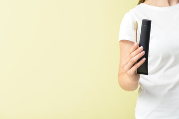 Black toothpaste with activated carbon and brush in female hands. Copy space for text