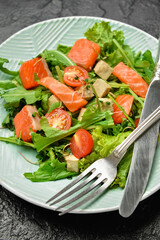 Plate with fresh salad on dark background, closeup