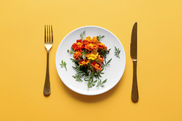 Creative composition with plate, cutlery and blooming marigold flowers on color background