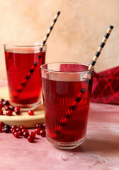 Glasses with tasty cranberry juice on color background