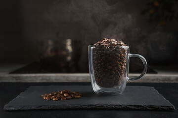 A steaming coffee cup isolated on a black background A cup of coffee beans with smoke.
