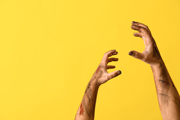 Hands of zombie on color background