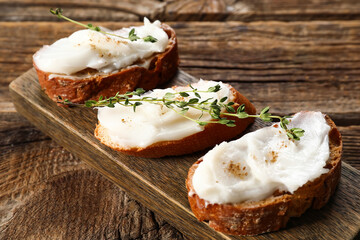 Pieces of bread with lard spread on wooden background
