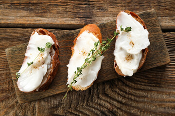 Pieces of bread with lard spread on wooden background