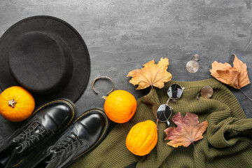 Trendy female accessories, pumpkins and dry leaves on dark background