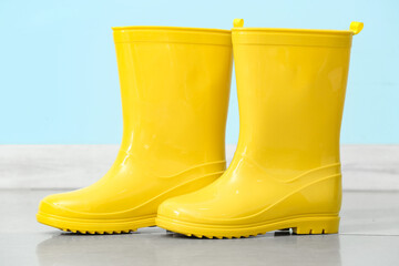 Yellow rubber boots near color wall