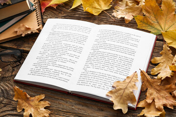Naklejka na ściany i meble Open book and autumn leaves on wooden background