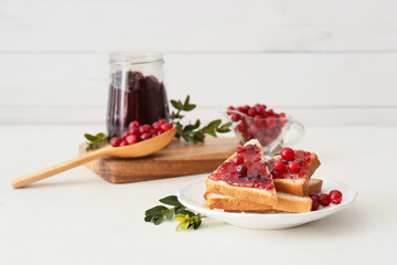 Plate of tasty toasts with lingonberry jam on table