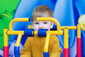 boy in a yellow sweater in the playroom