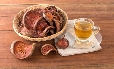 The Bael fruit juice in a glass and dried Bael fruit placed on the wooden