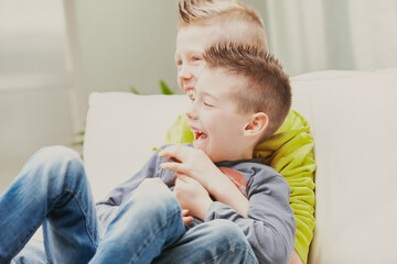 Two fun loving young brothers cuddling and laughing