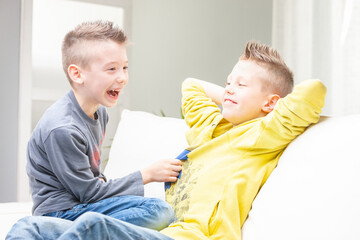 Cute funny young boy laughing at his brother