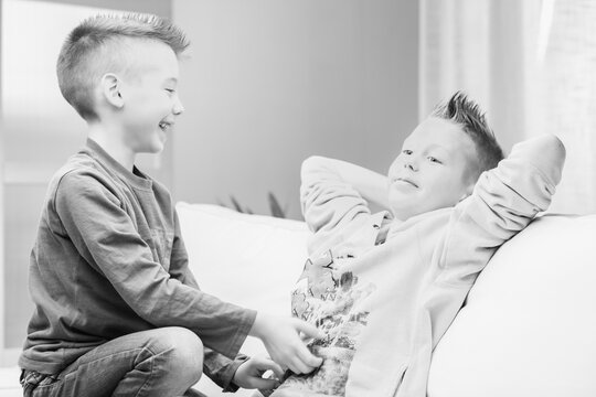 Greyscale image of two young brothers having fun