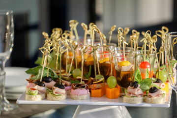 Appetizers on the white plate on a buffet table. High quality photo