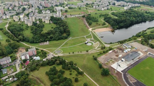 Central park of Jonava city with football field and old block apartment buildings, fly over view