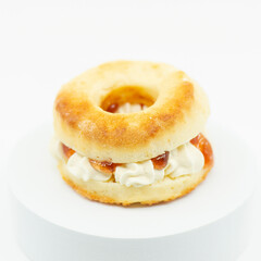 Closeup of a fresh baked scone with fresh cream and raspberry jam.