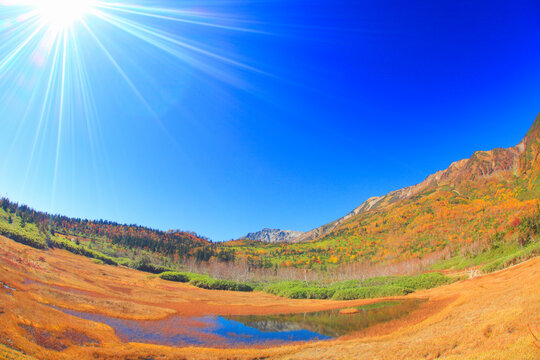 浮島湿原の池に映る紅葉の白馬岳と太陽の光芒, 小谷村,北安曇郡,長野県